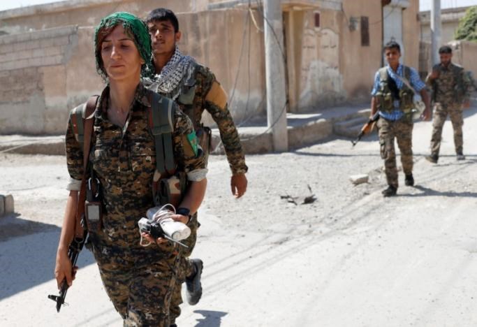 Sheen Abrahim, nữ tay súng YPG cùng các tay súng khác trên đường phố Raqqa, ngày 16-6. Ảnh: REUTERS