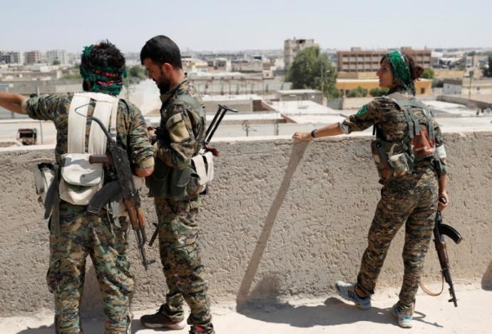 Sheen Abrahim, nữ tay súng YPG cùng các tay súng khác trên mái một tòa nhà ở Raqqa, ngày 16-6. Ảnh: REUTERS